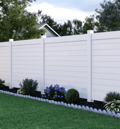 White vinyl privacy fence in yard.