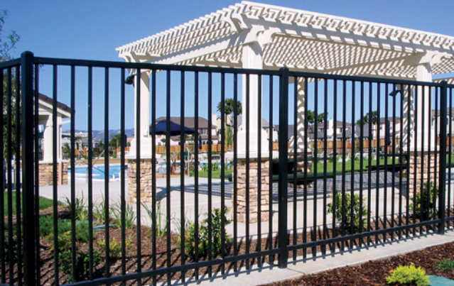 A gated area with a pool and gazebo.